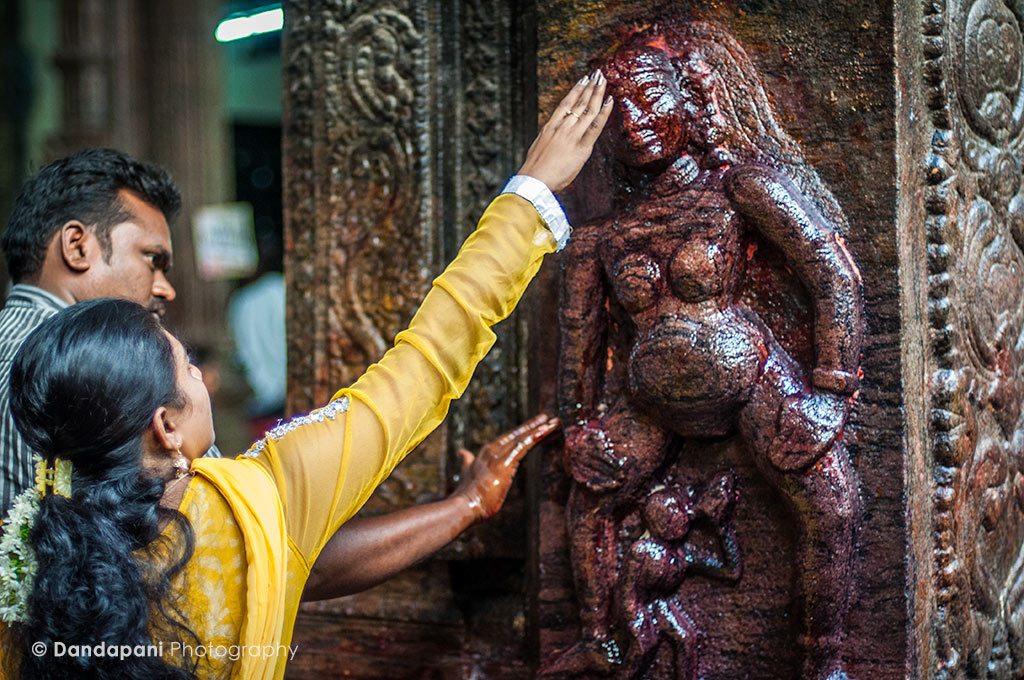 A couple worships at one of the smaller shrines, a fertility shrine, known to help couples conceive a child. 