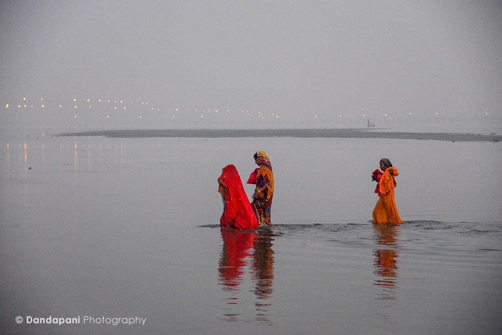 3 women walk across some of the shallowers parts of the river