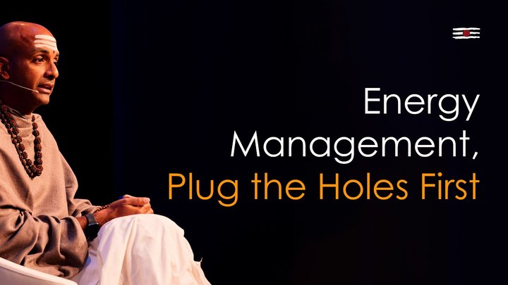Dandapani seated on stage beside the title Energy Management, Plug the Holes First.