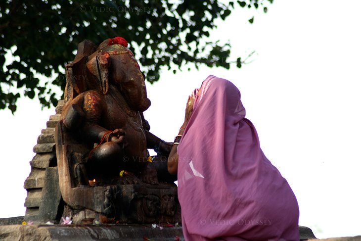 A local villager worships Lord Ganesha at shrine outside the protected temples of Khajuraho in India