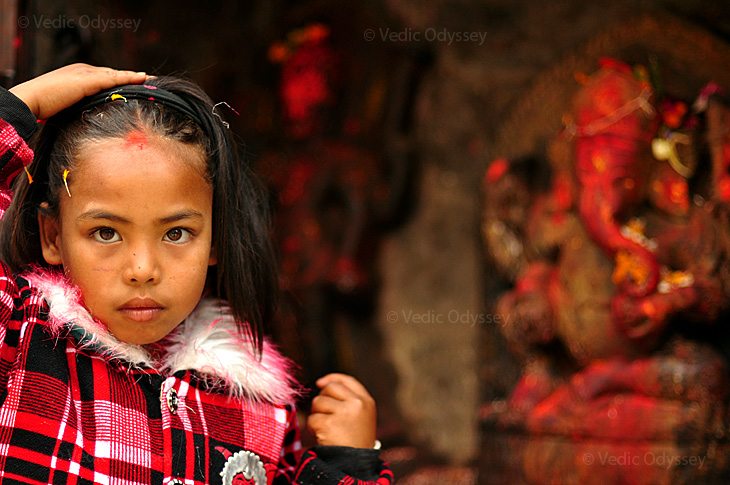 A young girl prays to Ganesha in the city of Kathmandu, Nepal.