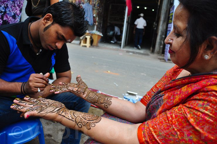 A henna artists in New Delhi India tattoos a lady