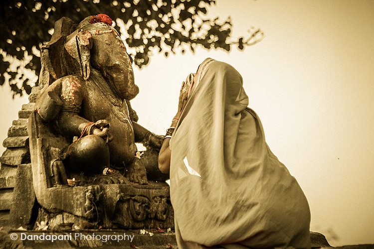 A lady worships Ganesha in the morning at a shrine outside the famed temples of Khajuraho, North India.