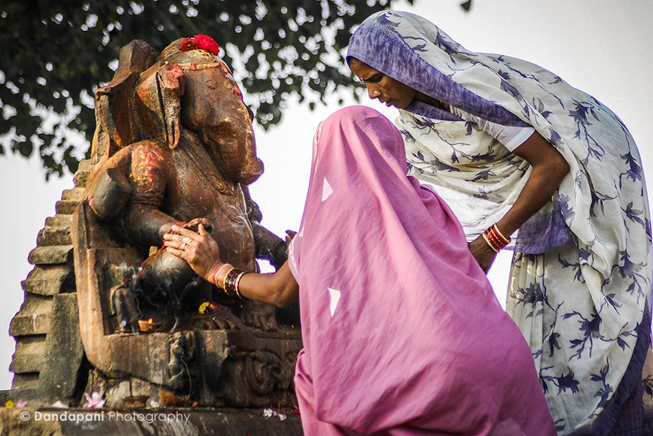 Two ladies from the local village worship at an outdoor Ganesha shrine at the famed temples of Khajuraho, North India.