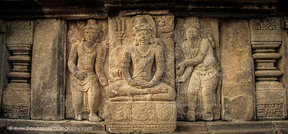 A carving on a large panel on one of the walls of the ancient Prambanan Hindu Temple in Central Java, Indonesia, depicts two students with they meditating guru. 