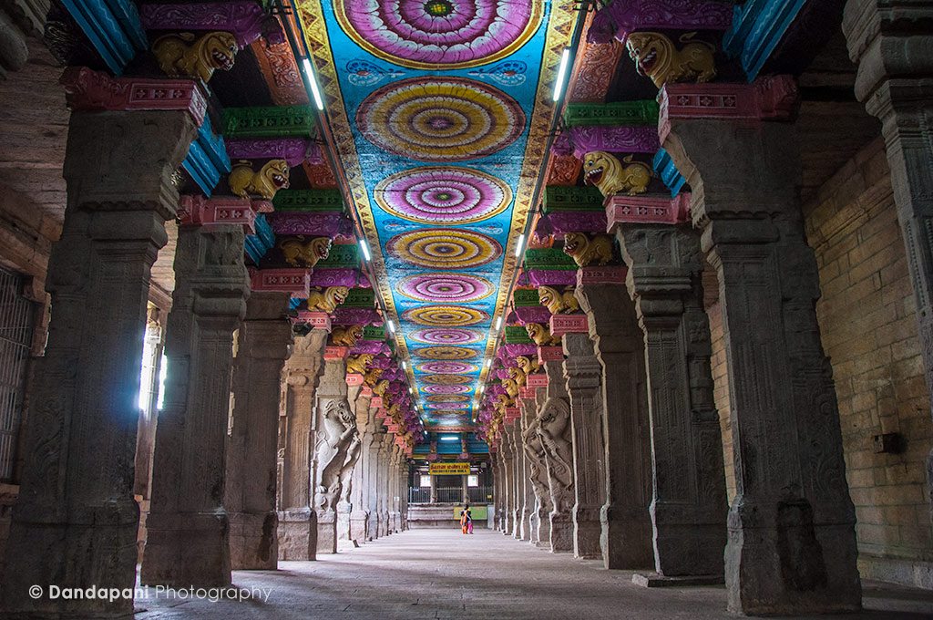 The massive hallways of the temple lined with gigantic pillars and colorfully painted ceilings.