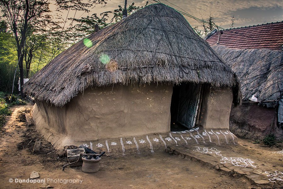 A traditional village home in south India. Walls made of mud with a tatted roof and beautiful patterns made of white rice flour decorate the front of the home.