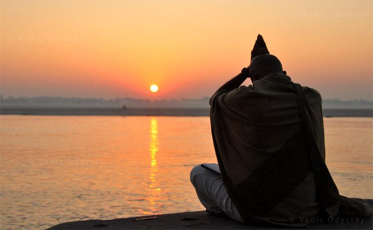 A Hindu priests worships God Siva in his morning practices as the sun rises over the Ganges river in the town of Varanasi, India.
