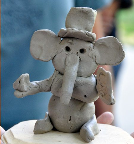 This Ganesha has a top hat and is holding a Kindle in His left hand.